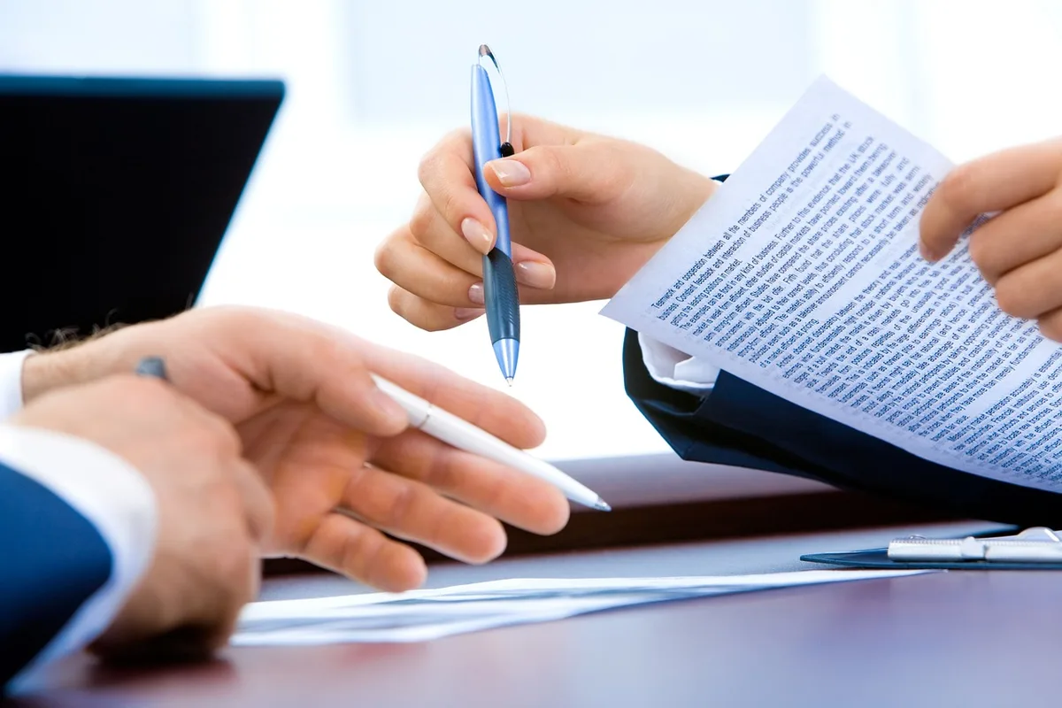 Propriétaire examinant un contrat de location sur une table avec notes